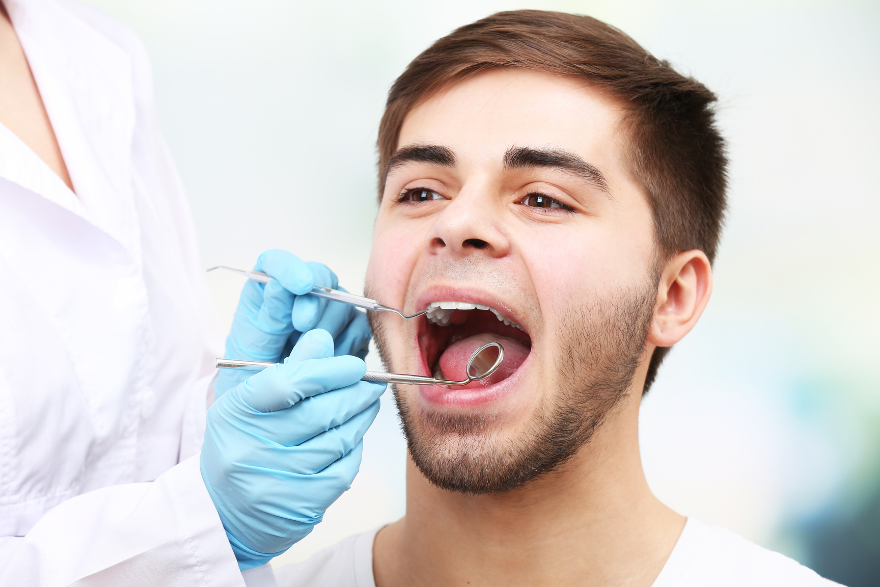 Dentist Examining Young Man
